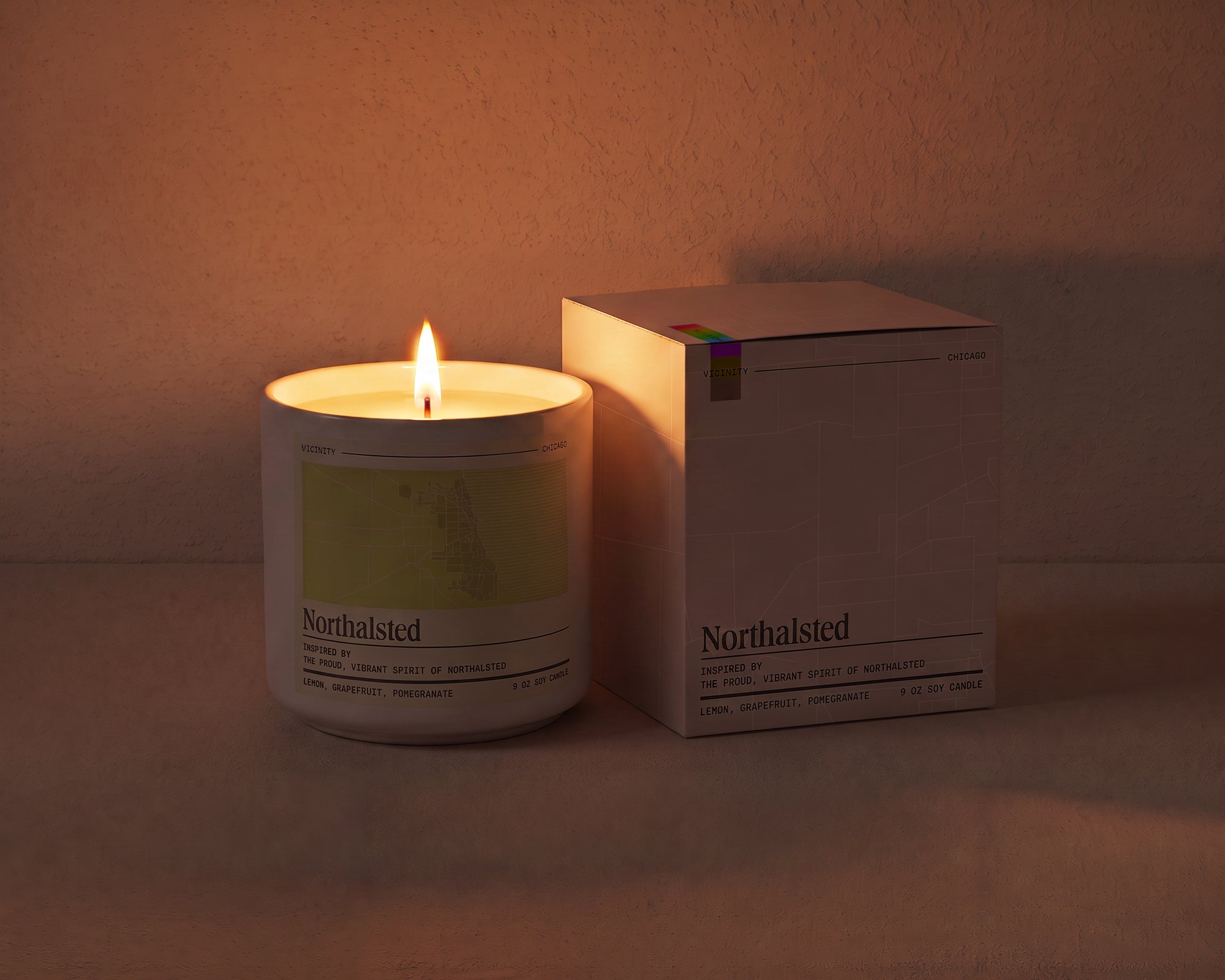 Northalsted 9 oz soy candle and its gift box, both printed with a Chicago neighborhood map, on a cream plaster surface
