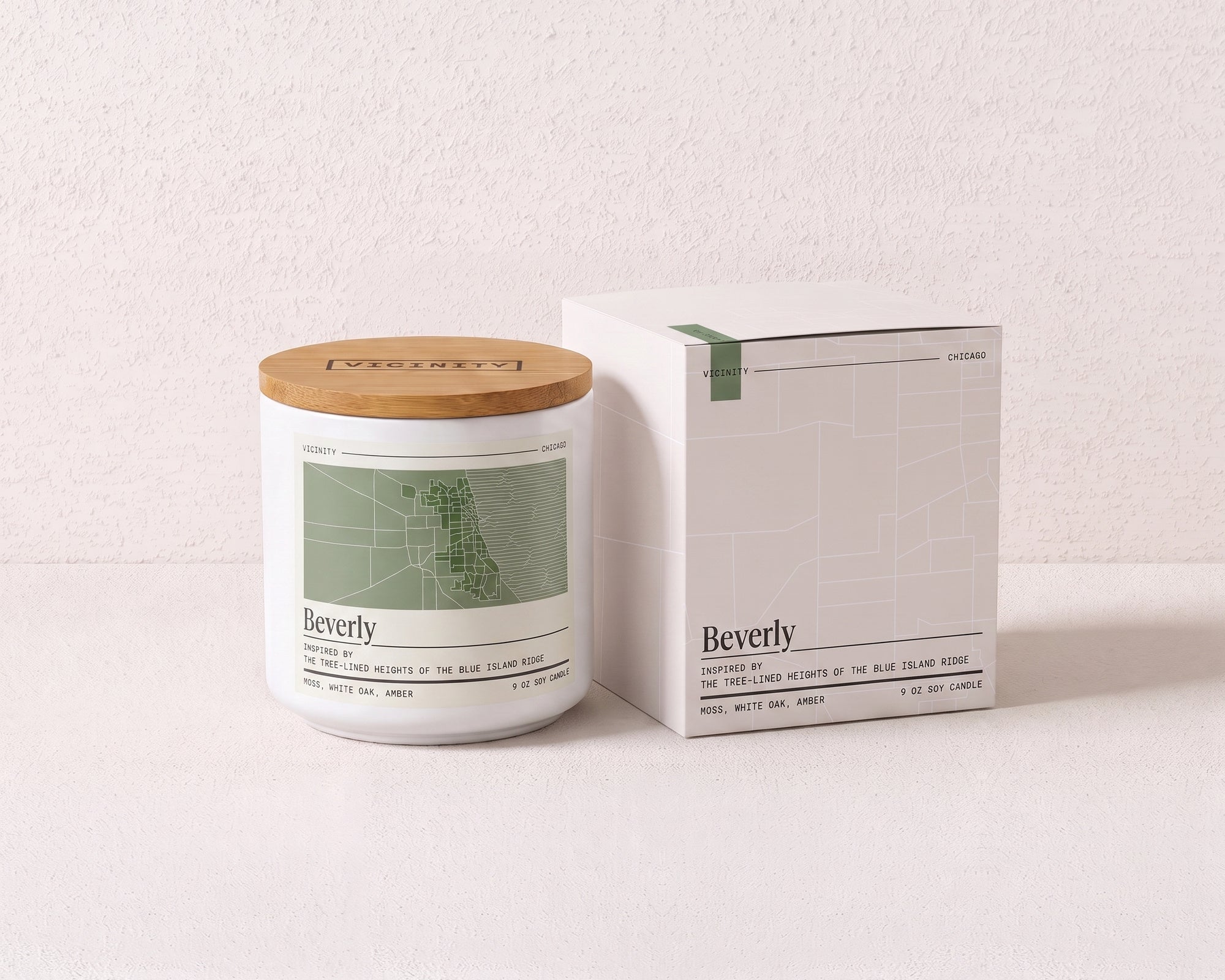 Beverly 9 oz soy candle and its gift box, both printed with a Chicago neighborhood map, on a cream plaster surface