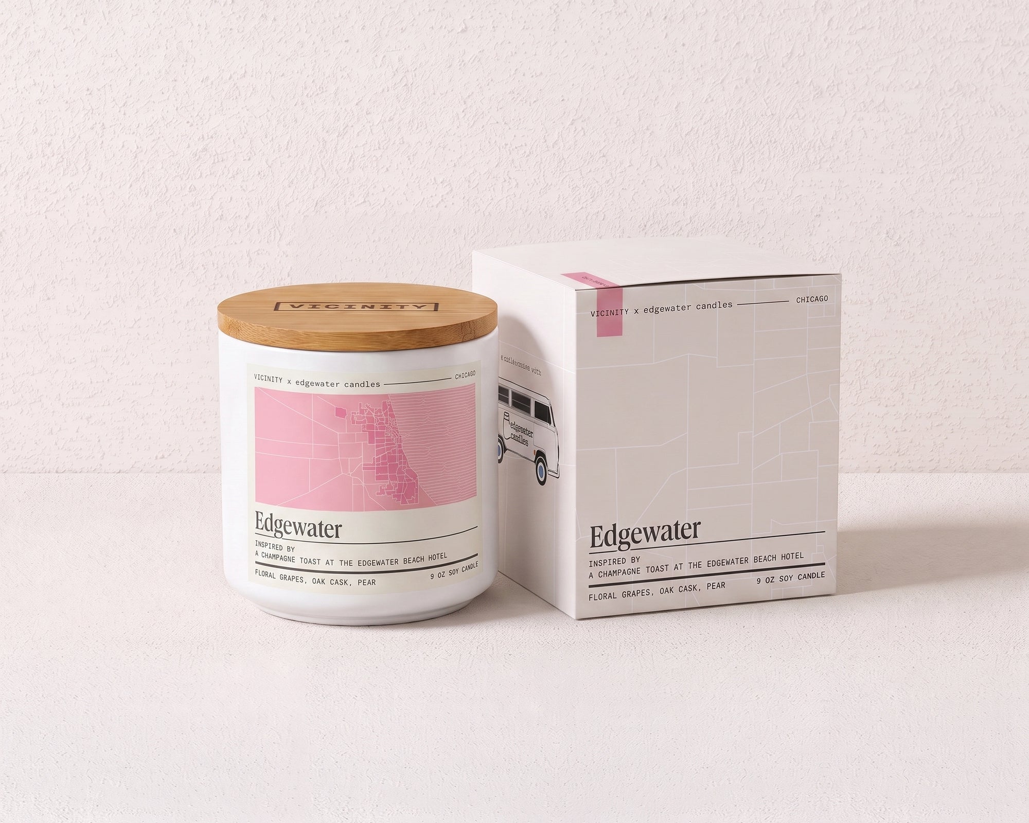 Edgewater 9 oz soy candle and its gift box, both printed with a Chicago neighborhood map, on a cream plaster surface