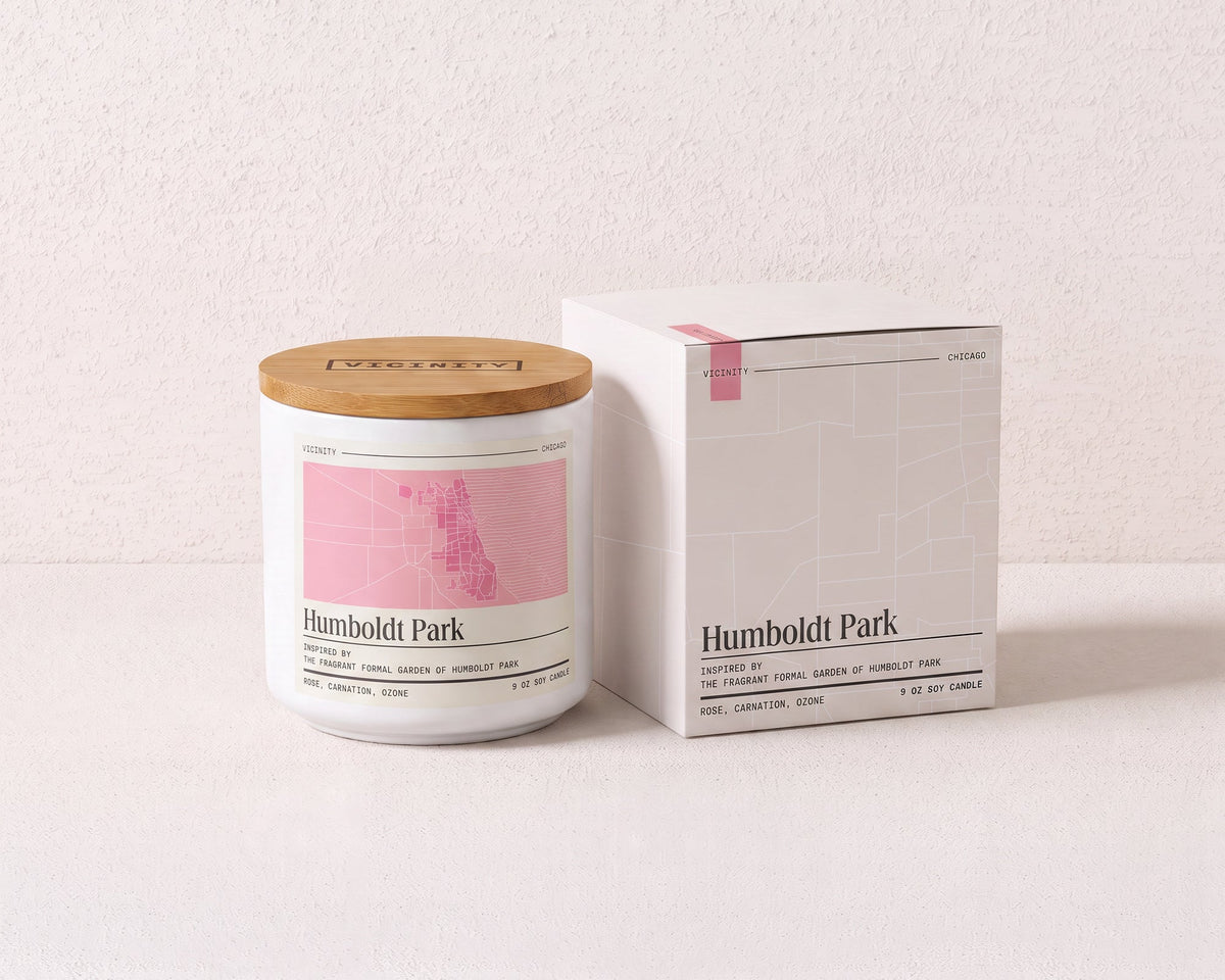 Humboldt Park 9 oz soy candle and its gift box, both printed with a Chicago neighborhood map, on a cream plaster surface