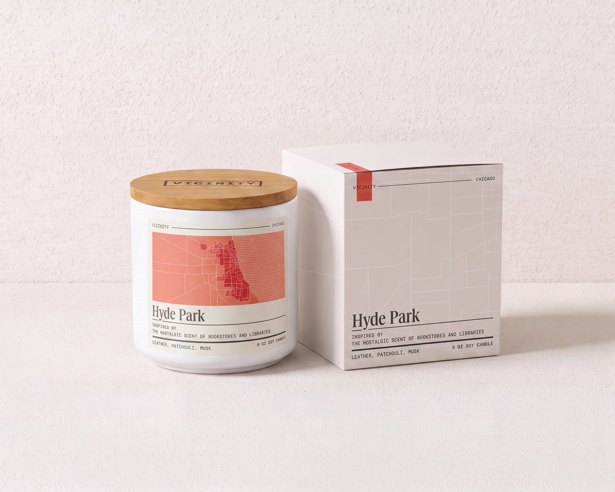 Hyde Park 9 oz soy candle and its gift box, both printed with a Chicago neighborhood map, on a cream plaster surface