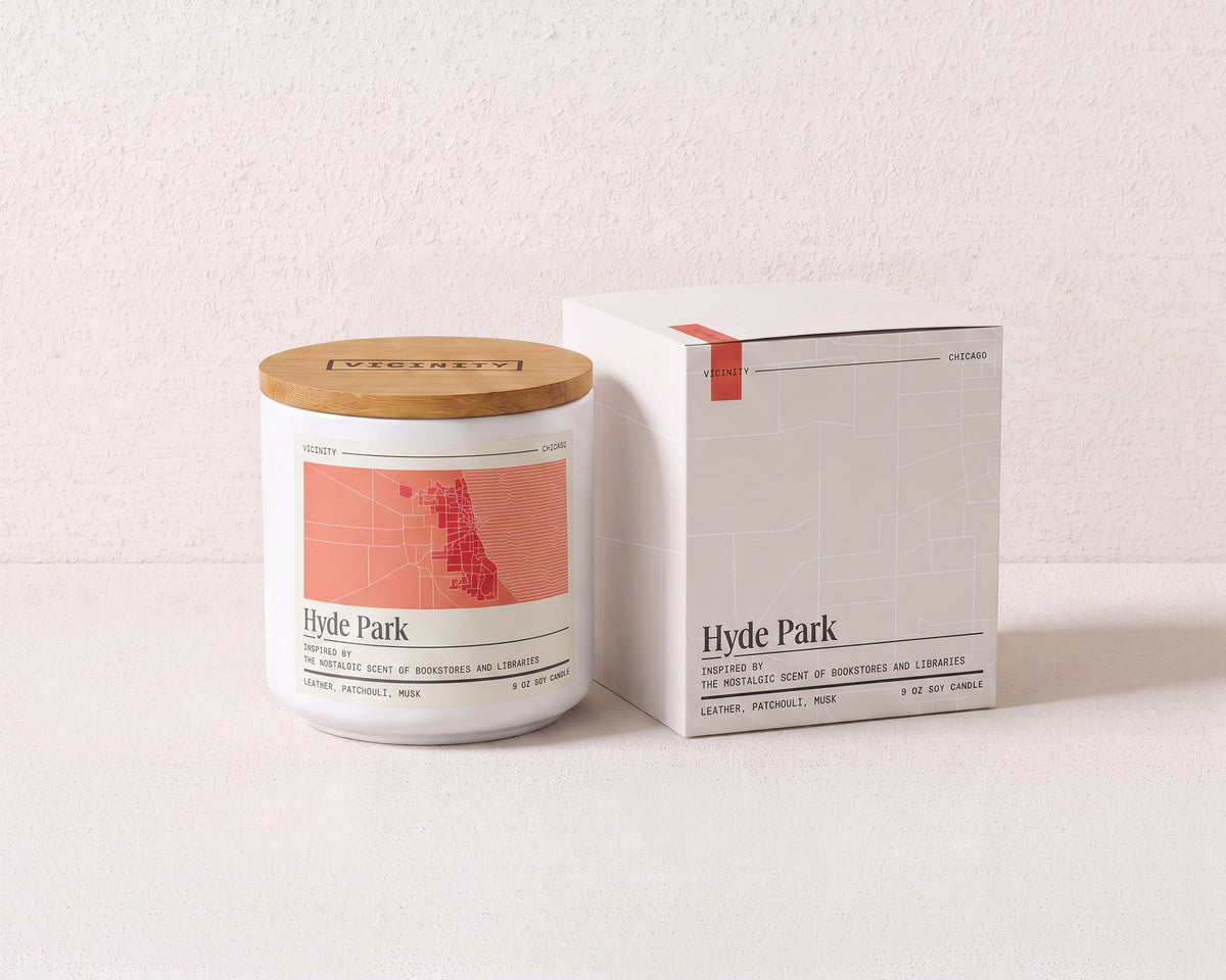 Hyde Park 9 oz soy candle and its gift box, both printed with a Chicago neighborhood map, on a cream plaster surface