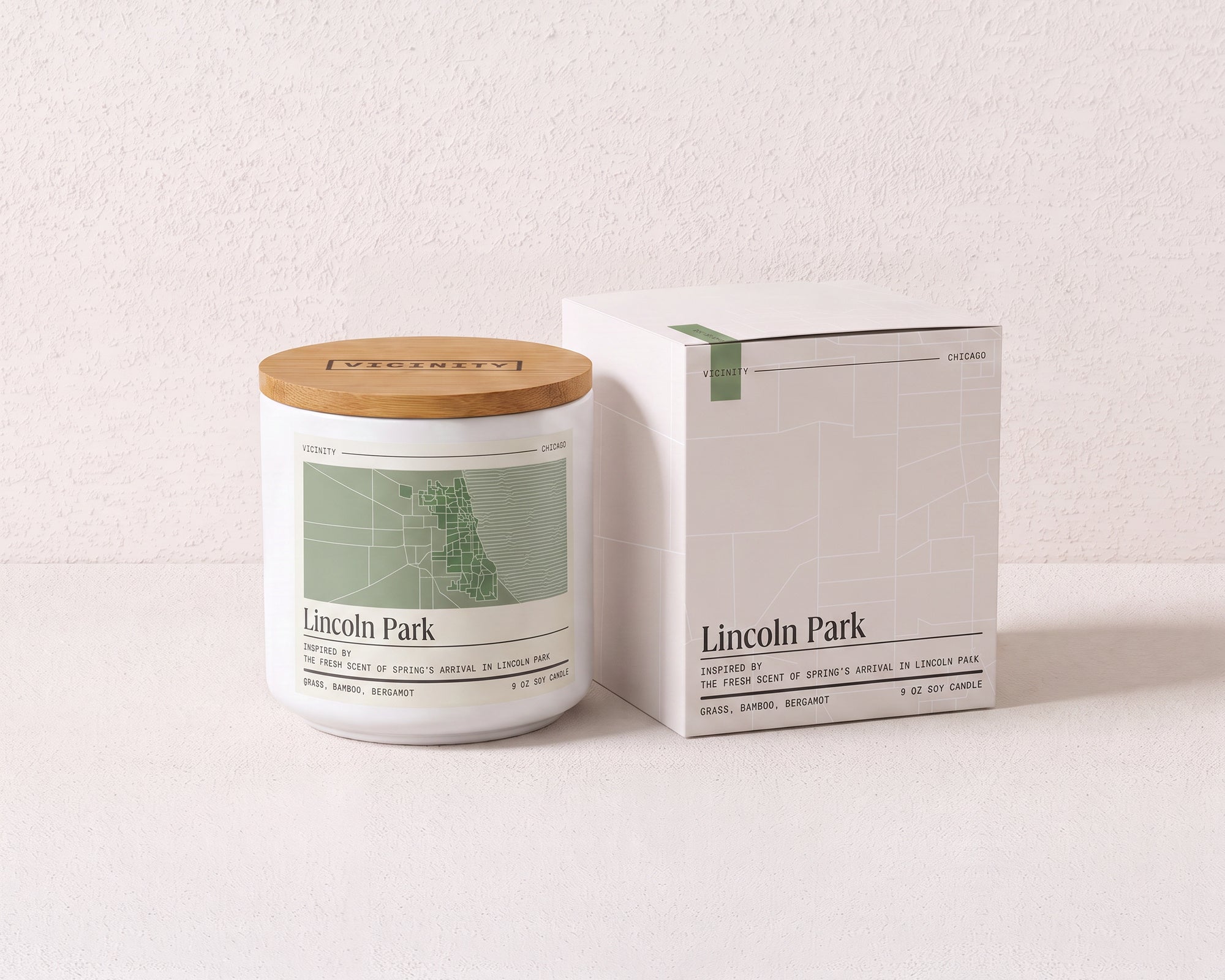 Lincoln Park 9 oz soy candle and its gift box, both printed with a Chicago neighborhood map, on a cream plaster surface