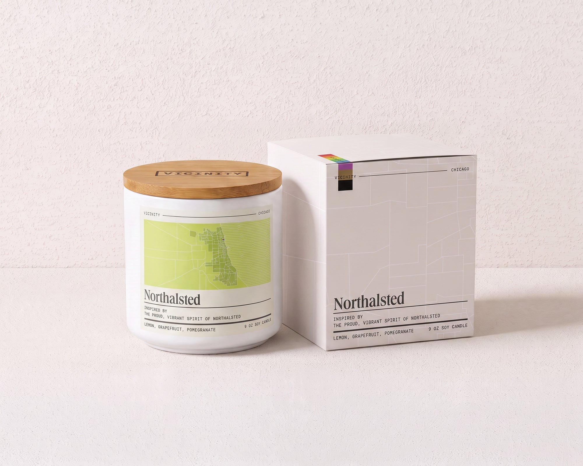 Northalsted 9 oz soy candle and its gift box, both printed with a Chicago neighborhood map, on a cream plaster surface